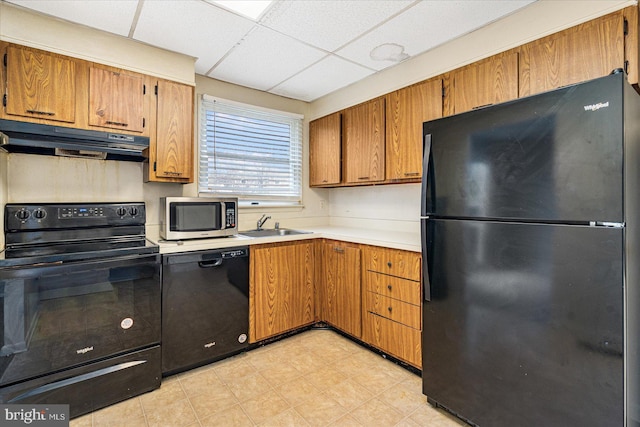 kitchen featuring sink, a drop ceiling, and black appliances