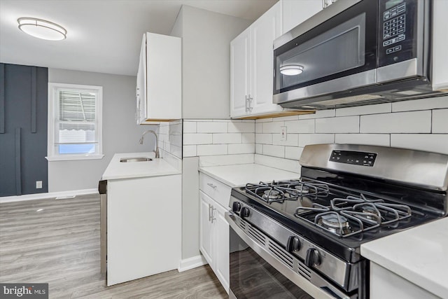 811 Rosedale Ave, Rosedale, MD 21237 - kitchen with white cabinets, sink, stainless steel appliances, and light hardwood / wood-style flooring