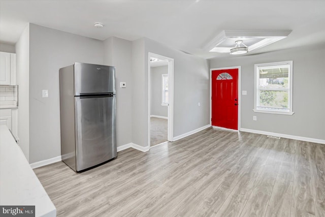 811 Rosedale Ave, Rosedale, MD 21237 - kitchen featuring decorative backsplash, stainless steel fridge, light hardwood / wood-style flooring, and white cabinetry