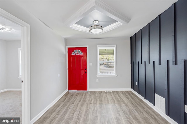 foyer entrance featuring light hardwood / wood-style floors and a raised ceiling