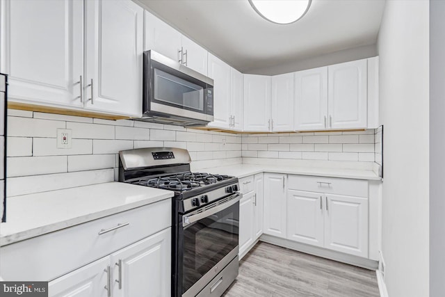 811 Rosedale Ave, Rosedale, MD 21237 - kitchen with decorative backsplash, white cabinetry, stainless steel appliances, and light hardwood / wood-style floors
