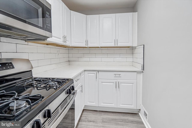 811 Rosedale Ave, Rosedale, MD 21237 - kitchen featuring tasteful backsplash, white cabinetry, stainless steel appliances, and light hardwood / wood-style flooring