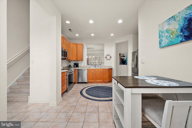 kitchen with sink, pendant lighting, a breakfast bar area, light tile patterned floors, and appliances with stainless steel finishes