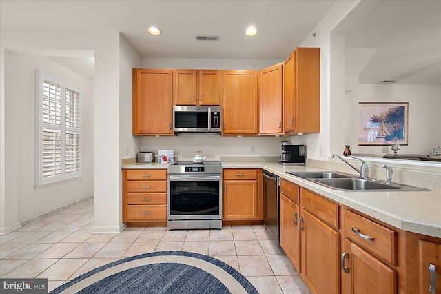 kitchen with sink, light tile patterned floors, and appliances with stainless steel finishes