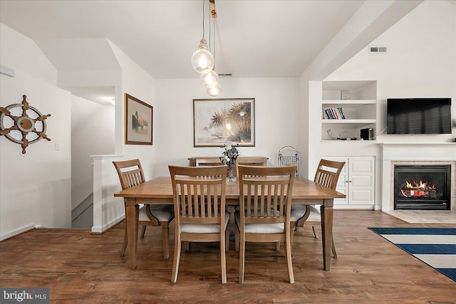 dining space featuring built in shelves and dark hardwood / wood-style flooring