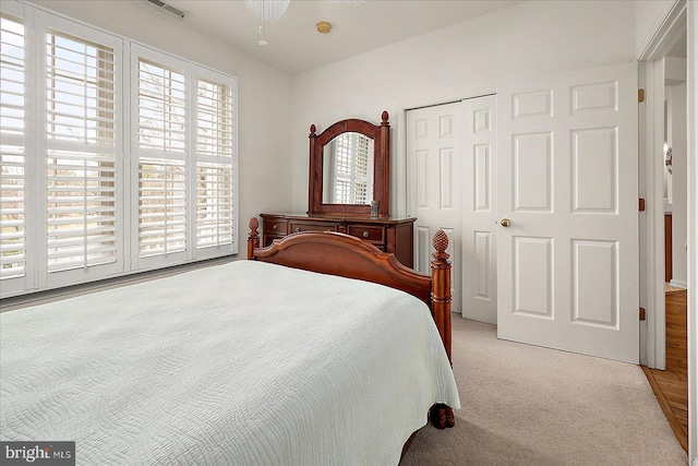 bedroom featuring a closet and light colored carpet