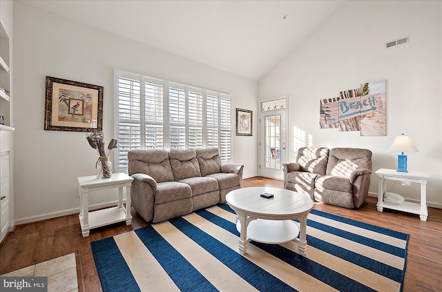 living room featuring dark hardwood / wood-style floors and high vaulted ceiling