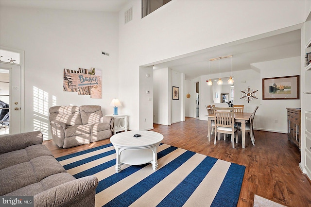 living room featuring dark hardwood / wood-style flooring and high vaulted ceiling