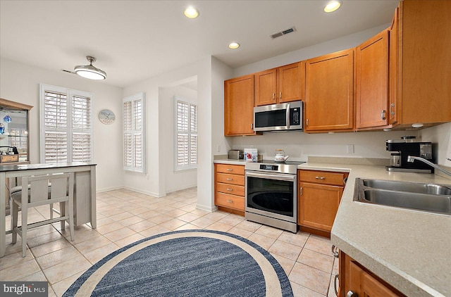 kitchen with plenty of natural light, light tile patterned floors, sink, and appliances with stainless steel finishes