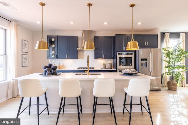 kitchen with a kitchen bar, stainless steel appliances, and a healthy amount of sunlight