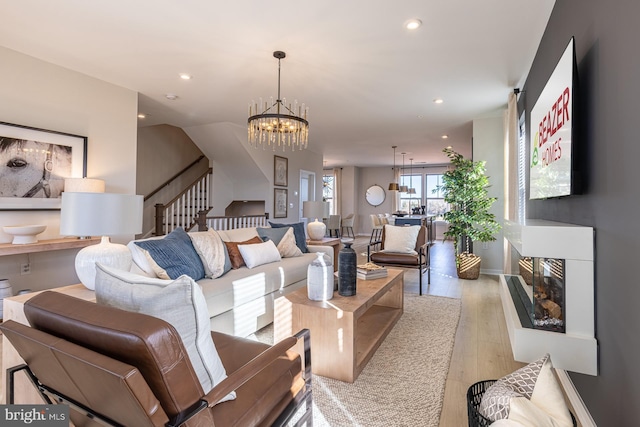 living room featuring light wood-type flooring and an inviting chandelier