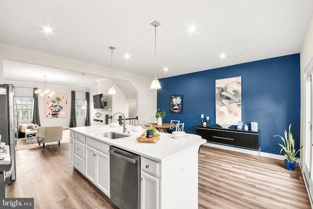 kitchen featuring white cabinetry, sink, pendant lighting, a center island with sink, and appliances with stainless steel finishes