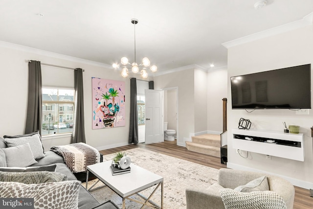 living room with hardwood / wood-style flooring, crown molding, and an inviting chandelier