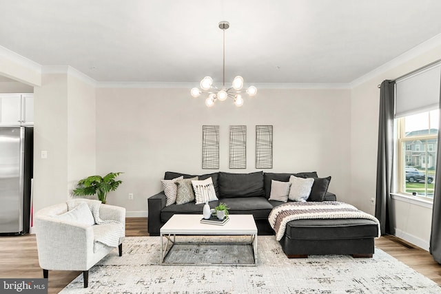 living room featuring ornamental molding, a chandelier, and light hardwood / wood-style floors