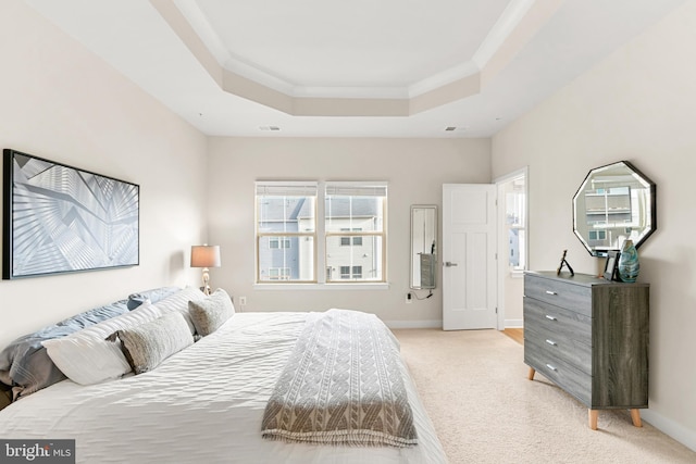 carpeted bedroom featuring a tray ceiling and crown molding