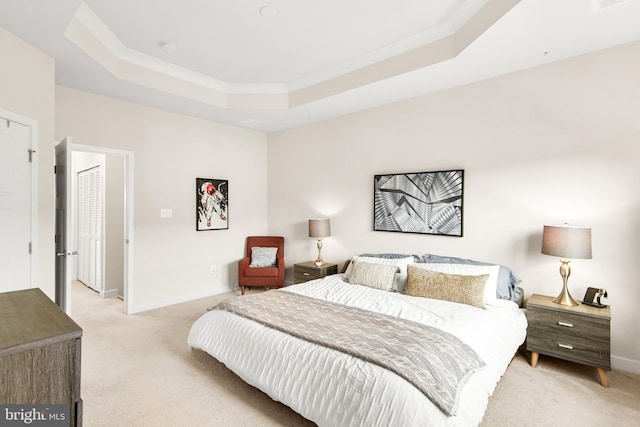 carpeted bedroom featuring a tray ceiling and crown molding