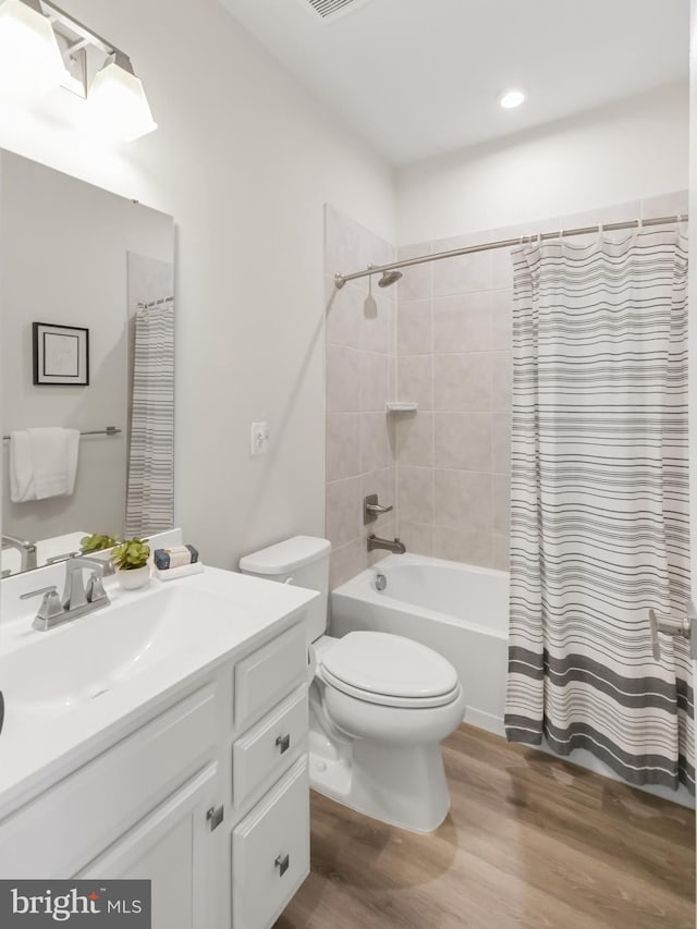 full bathroom featuring shower / bath combination with curtain, vanity, wood-type flooring, and toilet