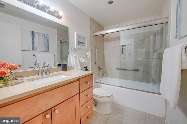 full bathroom featuring tile patterned flooring, vanity, shower / bath combination with glass door, and toilet