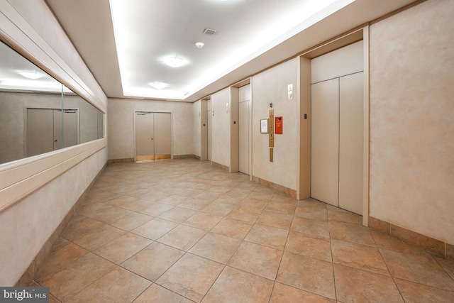 hallway with light tile patterned flooring and elevator