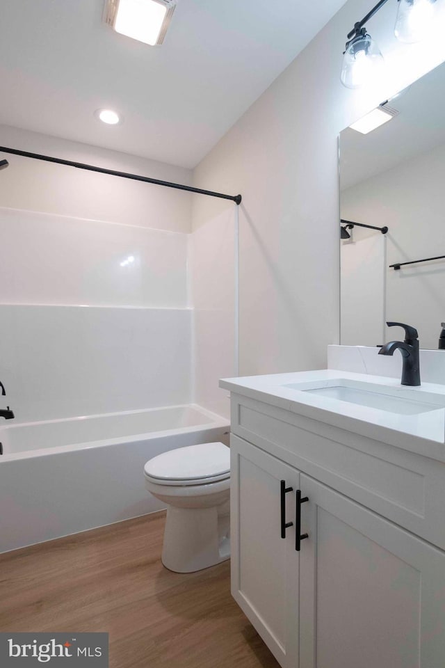 full bathroom with vanity, hardwood / wood-style flooring, toilet, and tub / shower combination