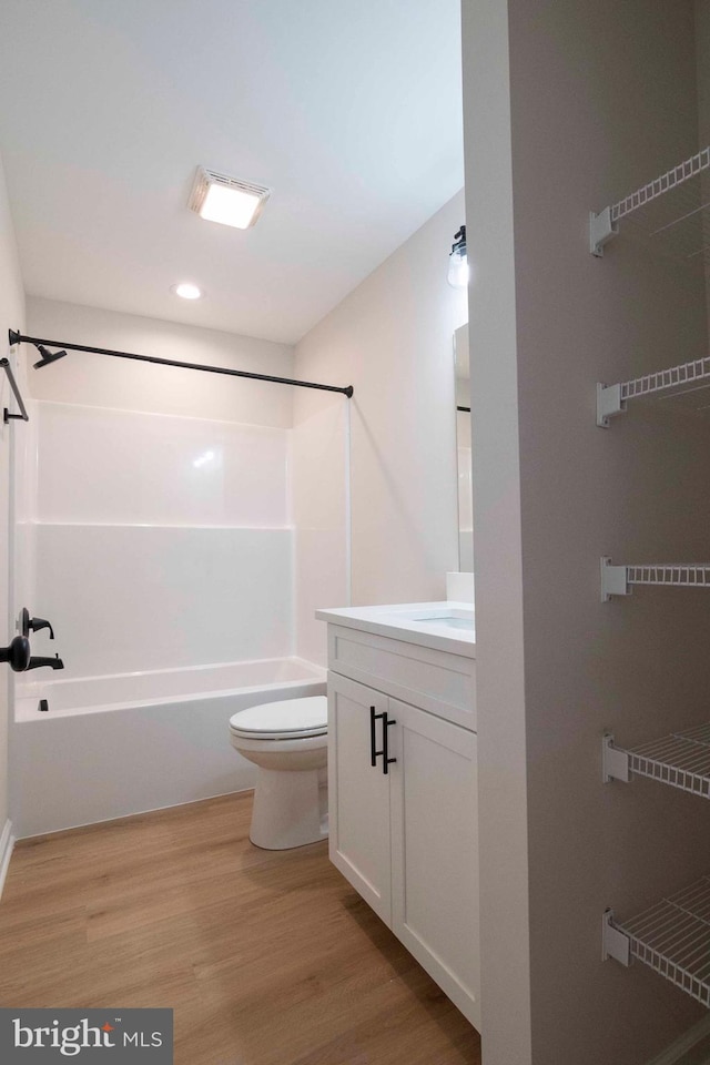 full bathroom featuring bathing tub / shower combination, hardwood / wood-style floors, vanity, and toilet