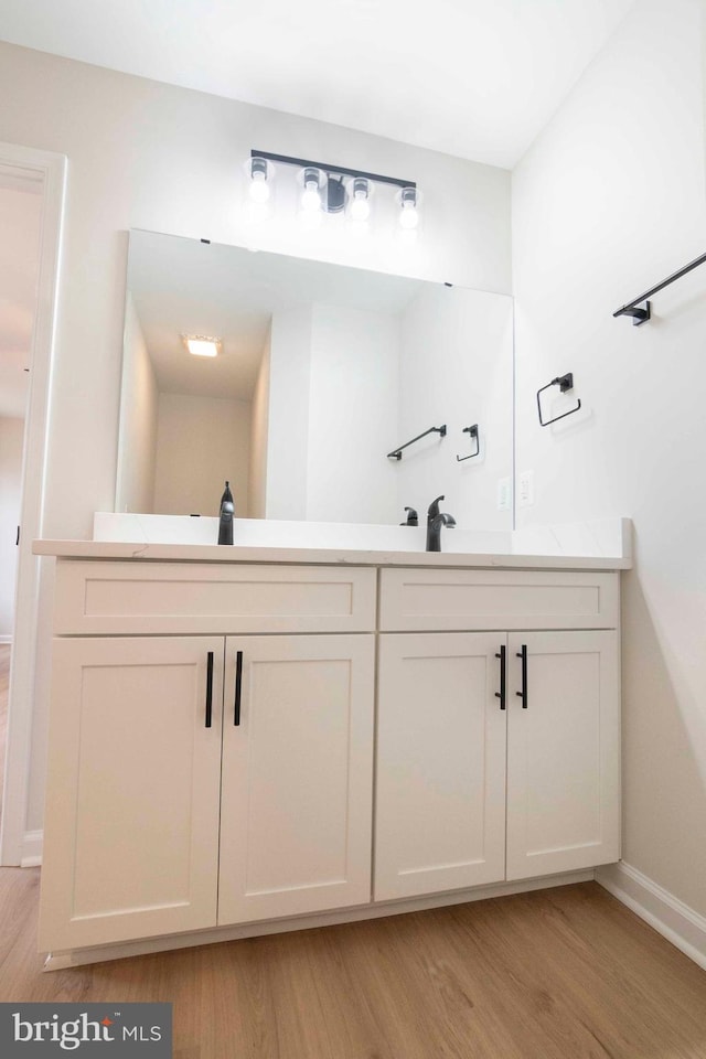 bathroom with vanity and wood-type flooring