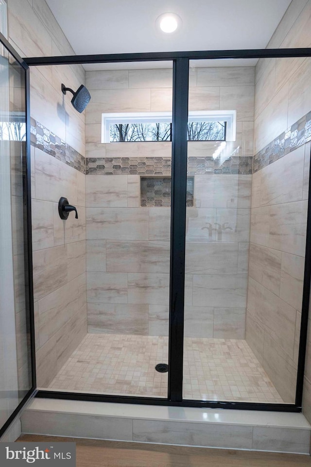 bathroom featuring a shower with door