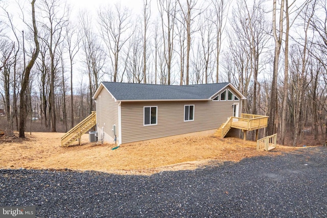 view of side of property featuring central air condition unit and a wooden deck