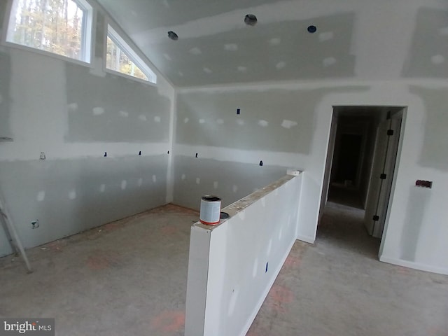 unfurnished room with vaulted ceiling