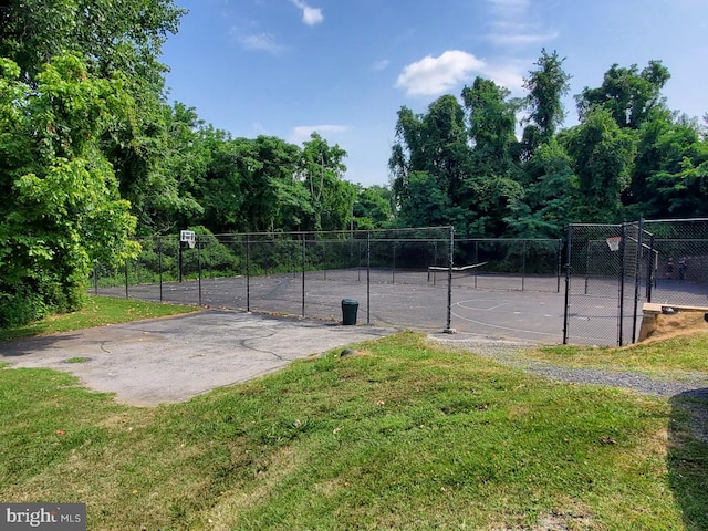 view of sport court with a lawn and basketball court