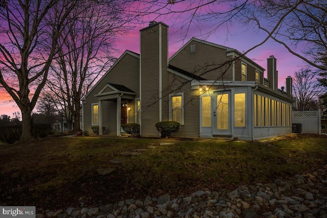 exterior space with central air condition unit and a sunroom