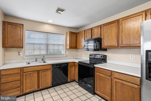 kitchen with light tile patterned flooring, sink, and black appliances