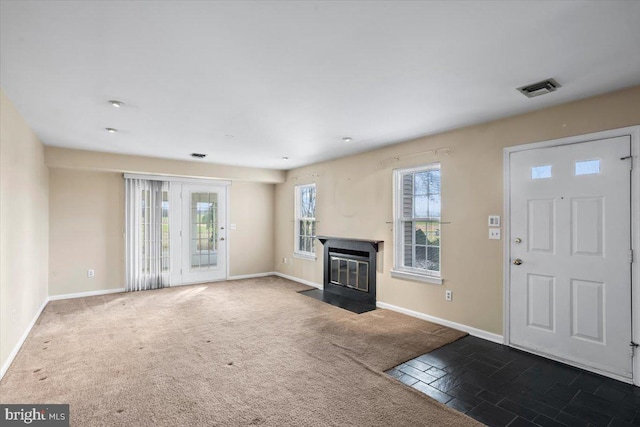 unfurnished living room with dark colored carpet