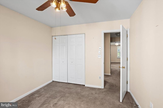 unfurnished bedroom featuring ceiling fan, a closet, and carpet