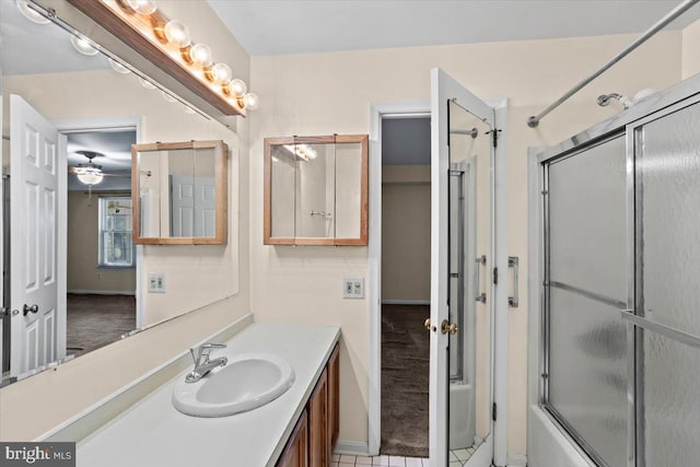 bathroom with tile patterned flooring, vanity, and enclosed tub / shower combo