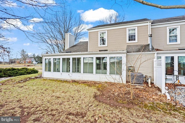 rear view of property featuring a sunroom and cooling unit