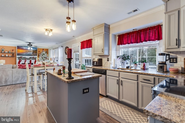 kitchen featuring gray cabinetry, a wealth of natural light, stainless steel appliances, backsplash, and a kitchen island