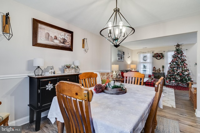 dining area featuring hardwood / wood-style flooring and a notable chandelier