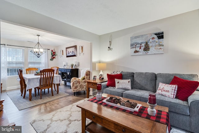 living room with wood-type flooring and an inviting chandelier