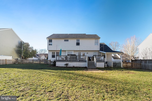 rear view of house with a yard and a deck