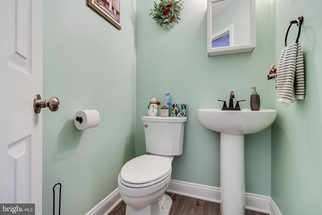 bathroom featuring hardwood / wood-style flooring and toilet