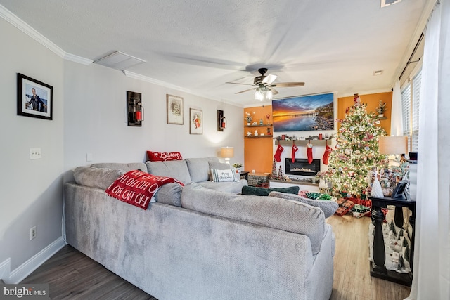 living room featuring a textured ceiling, hardwood / wood-style flooring, ceiling fan, and ornamental molding