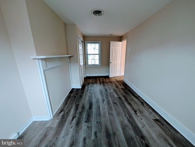 unfurnished dining area with visible vents, baseboards, and dark wood-style floors