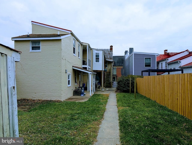 rear view of property with a lawn and a patio