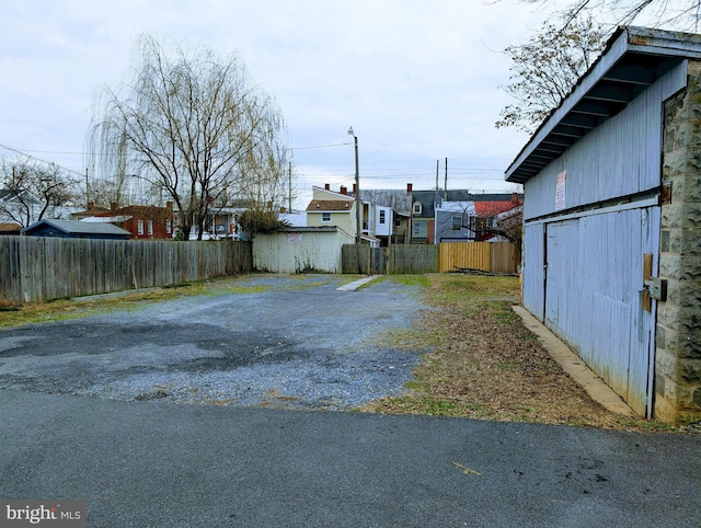 view of yard featuring fence and driveway