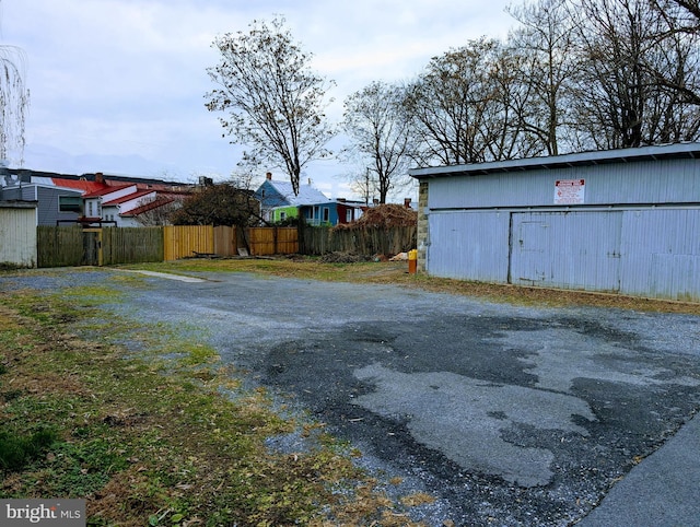 view of yard with an outbuilding, a pole building, and fence