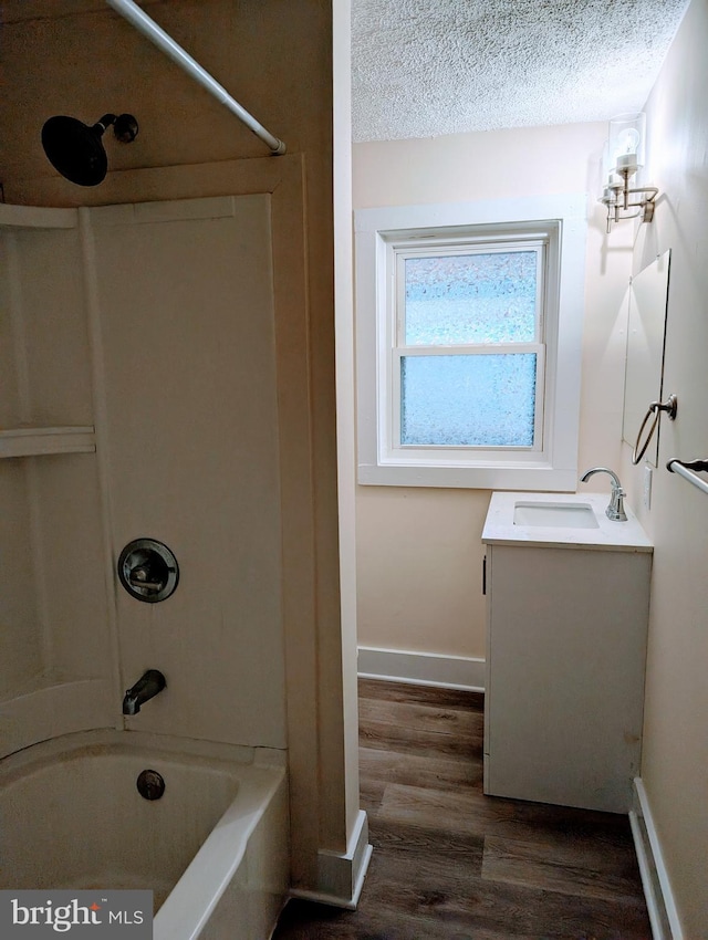 bathroom with bathing tub / shower combination, hardwood / wood-style floors, vanity, and a textured ceiling