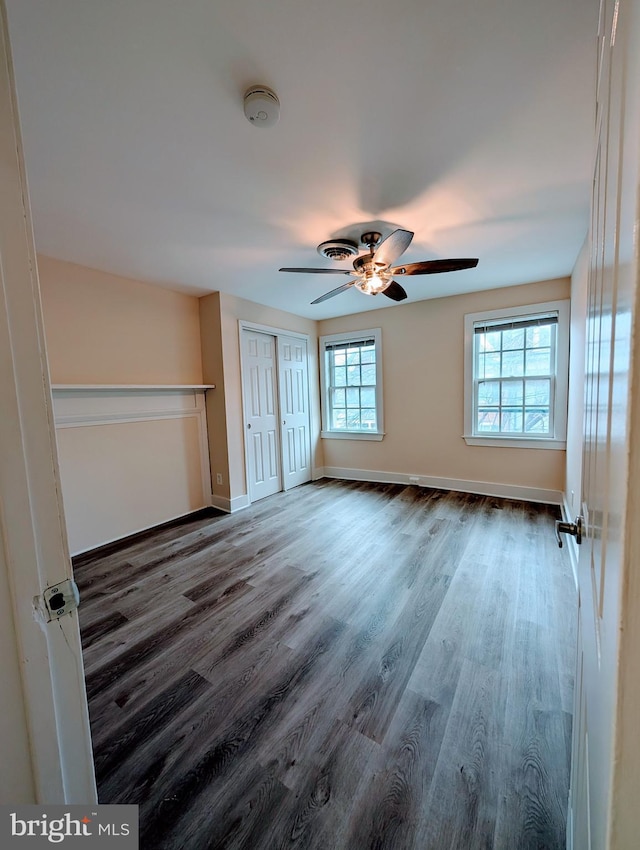 unfurnished bedroom with multiple windows, ceiling fan, and hardwood / wood-style flooring