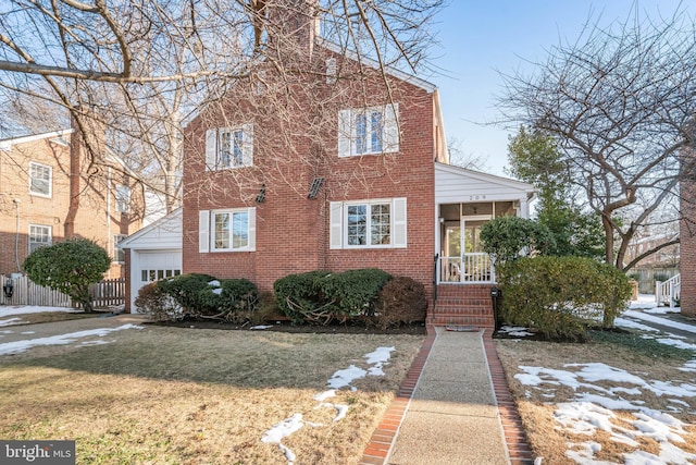 view of front of home featuring a sunroom, a front yard, a garage, and an outdoor structure