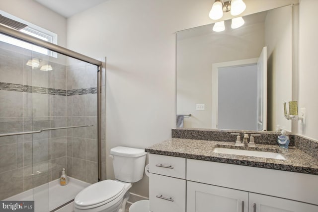 bathroom with toilet, a shower with door, and vanity